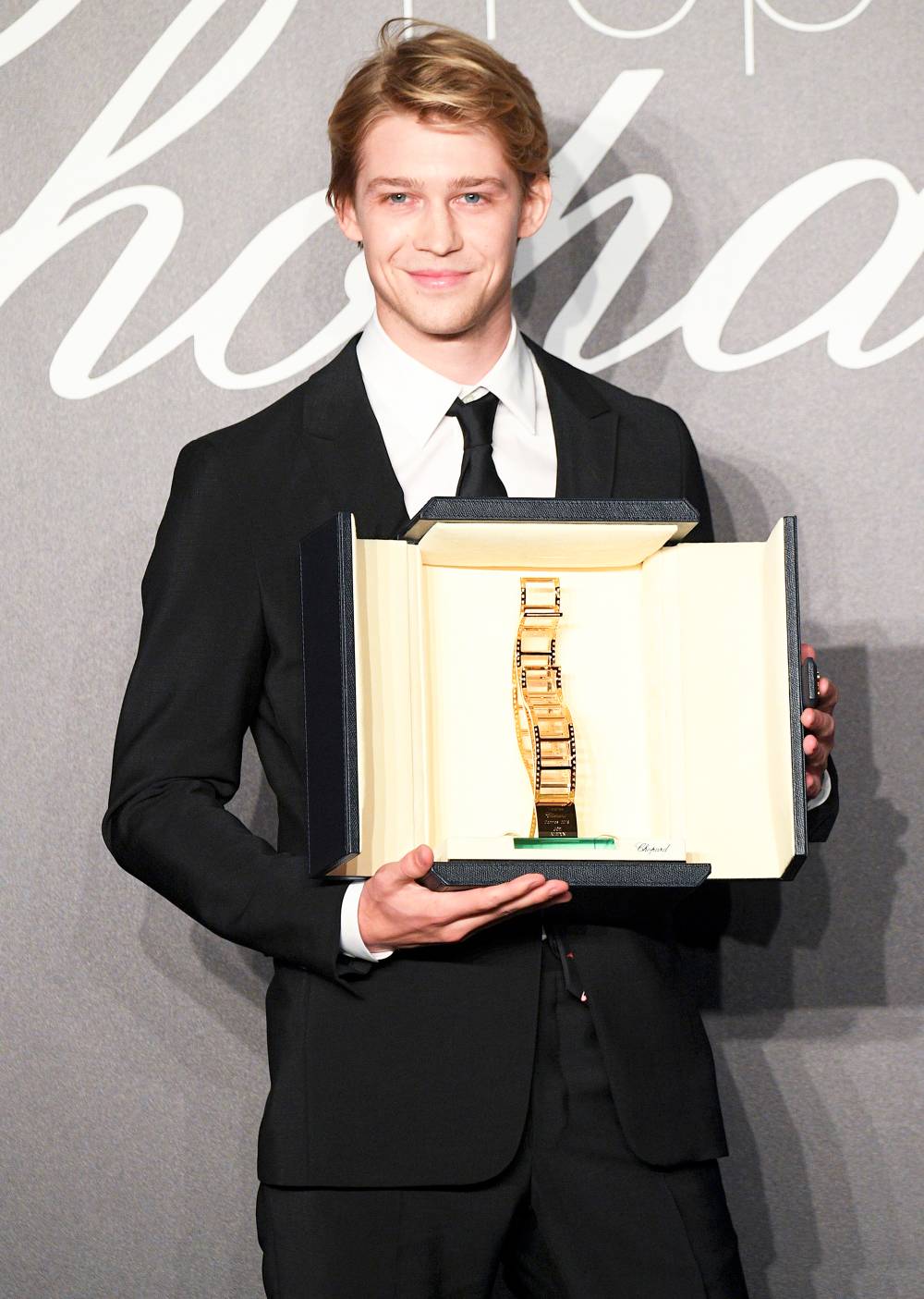 Joe Alwyn holds the throphy at Chopard Trophy photocall during the 71st annual Cannes Film Festival at Martinez Hotel on May 14, 2018 in Cannes, France.