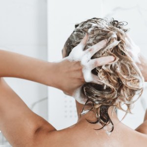 woman washes hair with hydrating shampoo