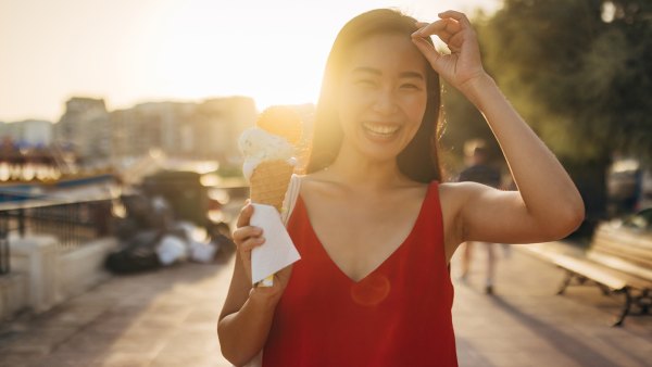 Portrait of a smiling woman eating ice cream and looking directly at the camera
