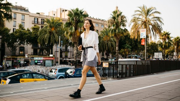 Pretty businesswoman carrying folder, walking in the city