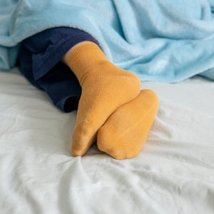 GettyImages-2196916526 Why Sleep Doctors Say Wearing Socks to Bed Might Actually Help You Fall Asleep Faster