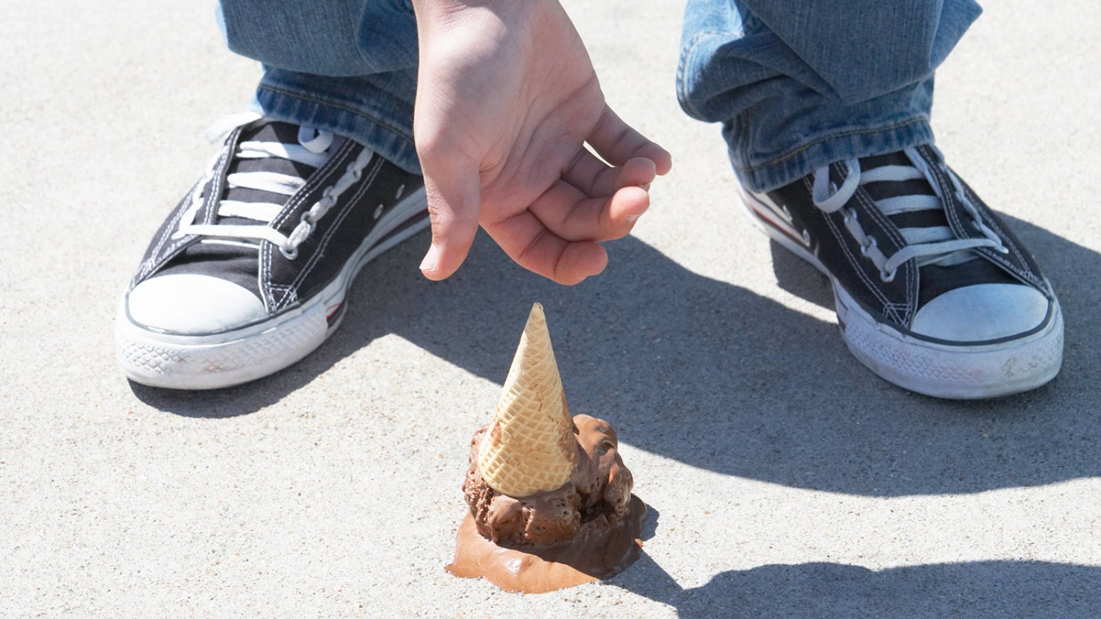 Young Man Reaching for Dropped Ice Cream Cone