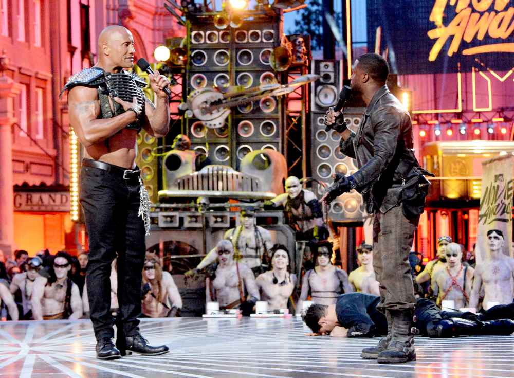 Dwayne Johnson and Kevin Hart speak onstage during the 2016 MTV Movie Awards.