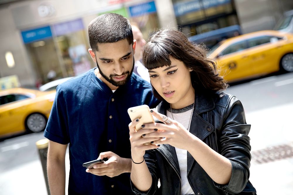 Sameer Uddin and Michelle Macias play Pokémon Go on their smartphones outside of Nintendo's flagship store, July 11, 2016 in New York City.