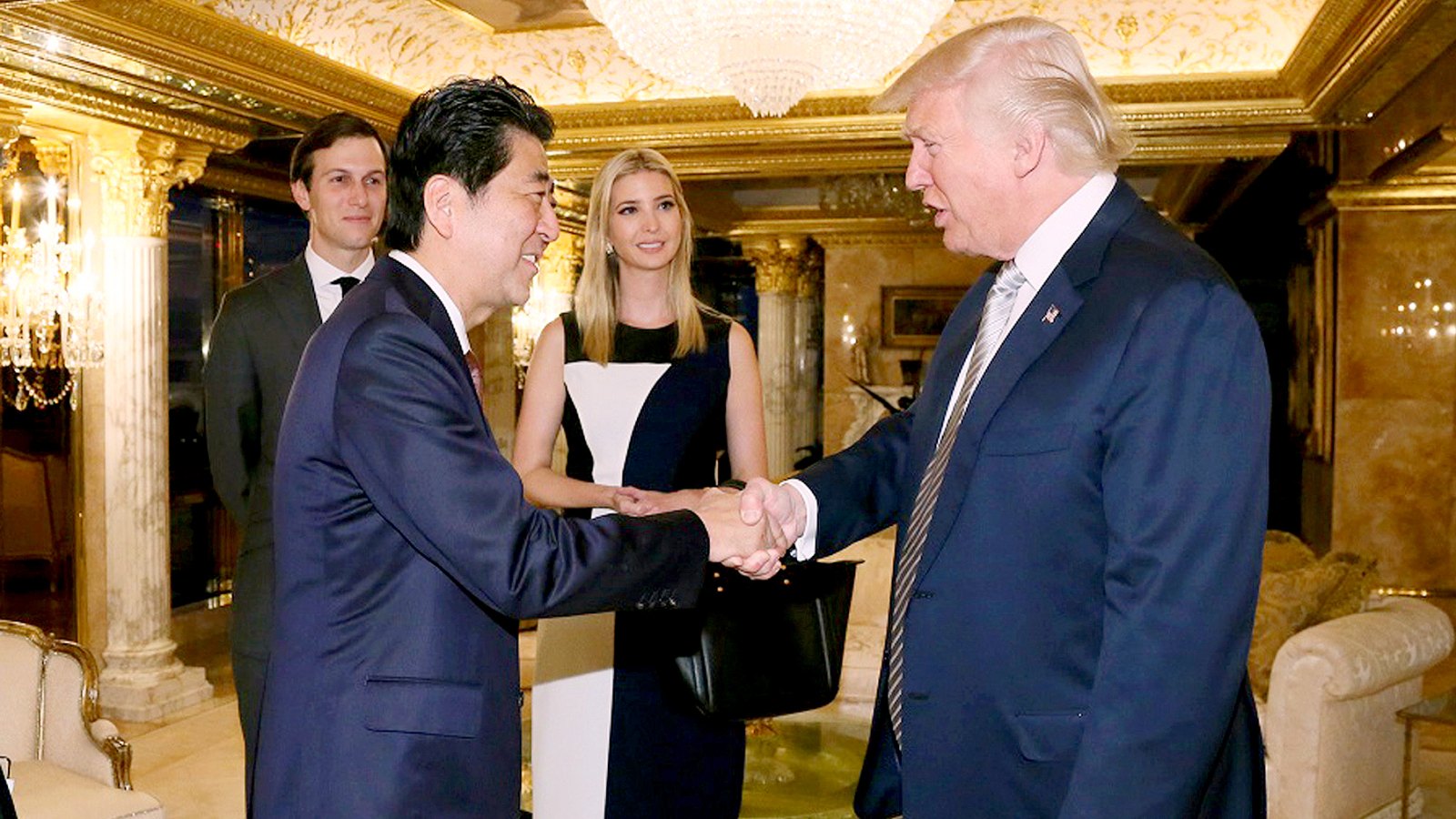 Japanese Prime Minister Shinzo Abe, front left, shakes hands with U.S. President-elect Donald Trump during a meeting as Ivanka Trump, back right, the oldest daughter of Donald Trump, and her husband, Jared Kushner, back left.