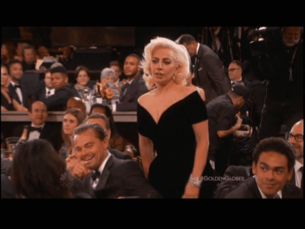 Lady Gaga walks by Leonardo DiCaprio at the Golden Globes 2016