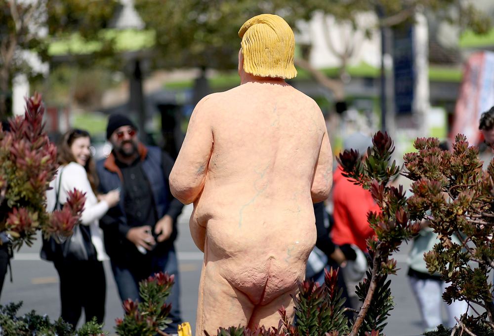 People gather around a statue depicting republican presidential nominee Donald Trump in the nude on August 18, 2016 in San Francisco, United States.