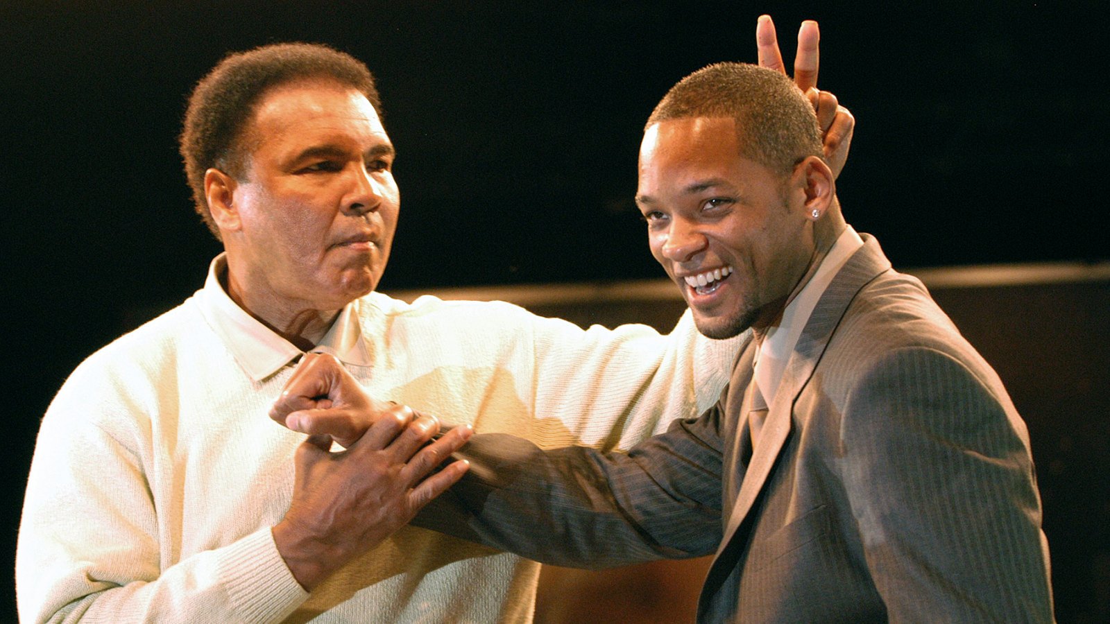 Muhammad Ali gestures behind the head of actor Will Smith at the Miami Art Basel Taschen book premiere of Ali's new book, 'GOAT - Greatest Of All Time' at the Miami Convention Center December 6, 2003 in Miami, Florida.