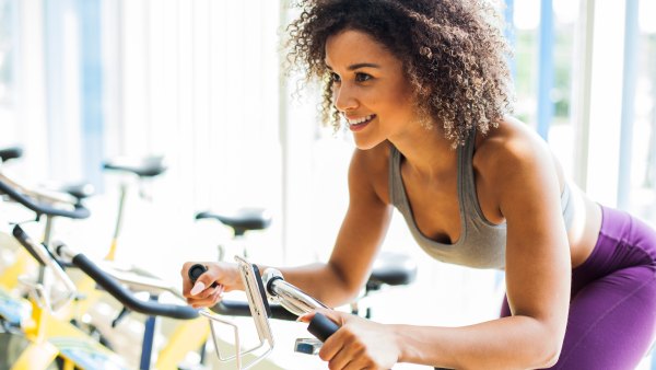 Woman Doing Cardio Exercises on a Stationary Bike at the Gym