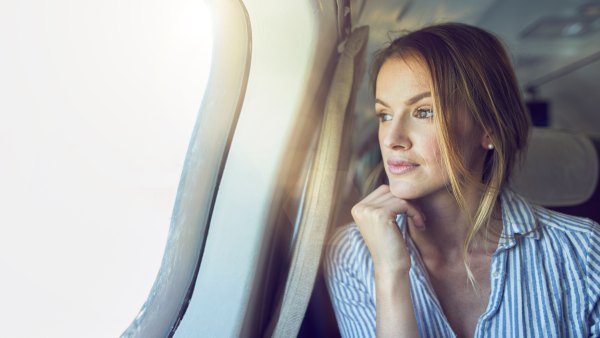 Serious woman looking out of airplane window