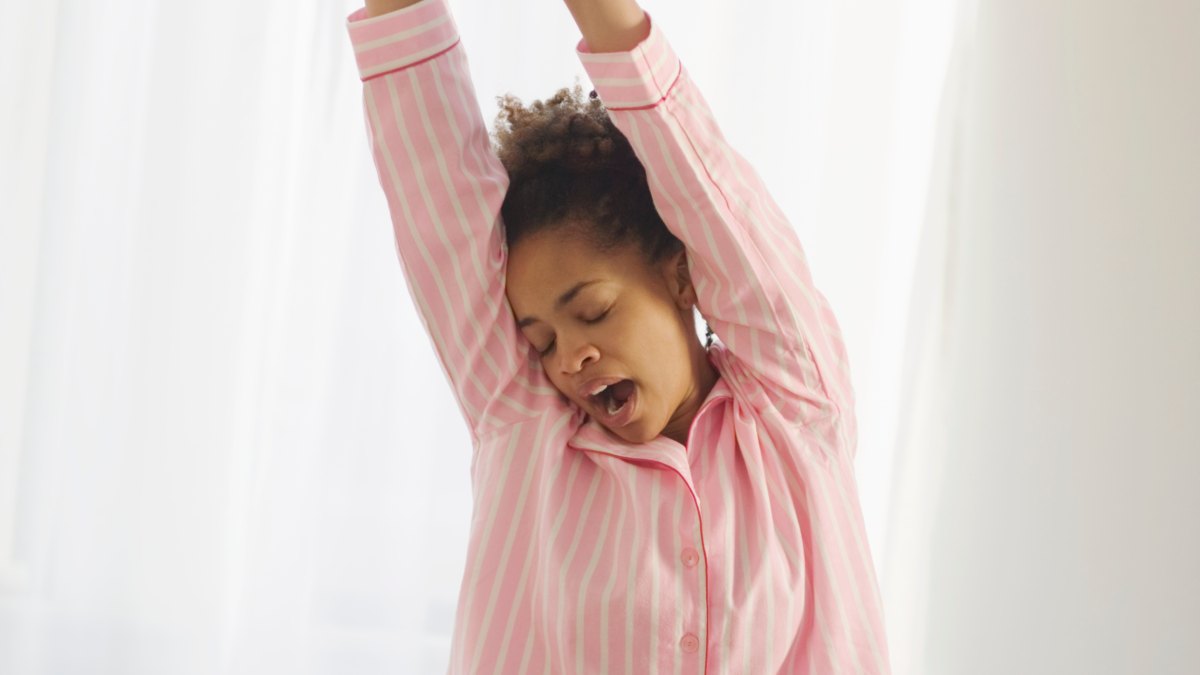Young woman stretching and yawning