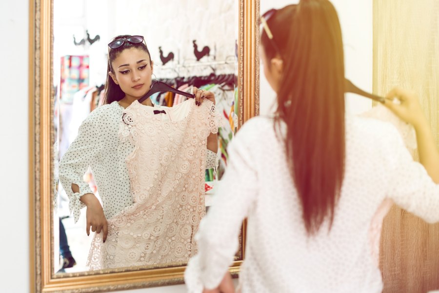 Woman admiring dress in store mirror