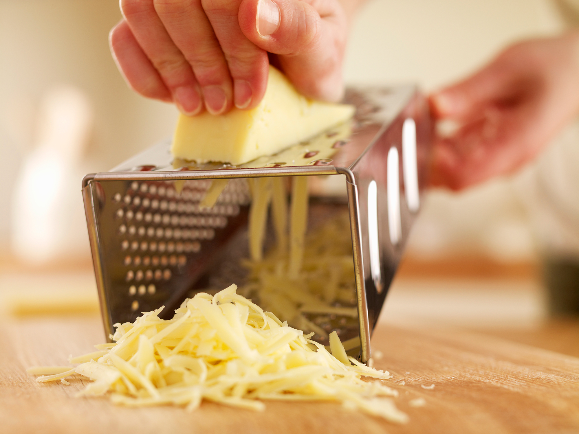 Woman shredded cheese with grater