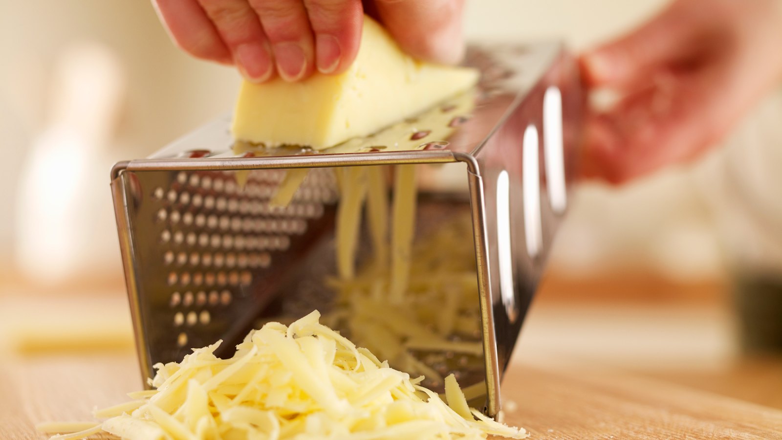 Woman shredded cheese with grater