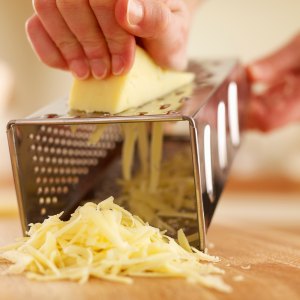 Woman shredded cheese with grater