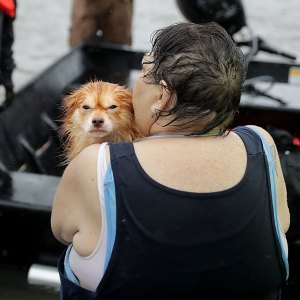 Rescue workers from Township No. 7 Fire Department and volunteers from the Civilian Crisis Response Team use a boat to rescue a woman and her dog from their flooded home during Hurricane Florence