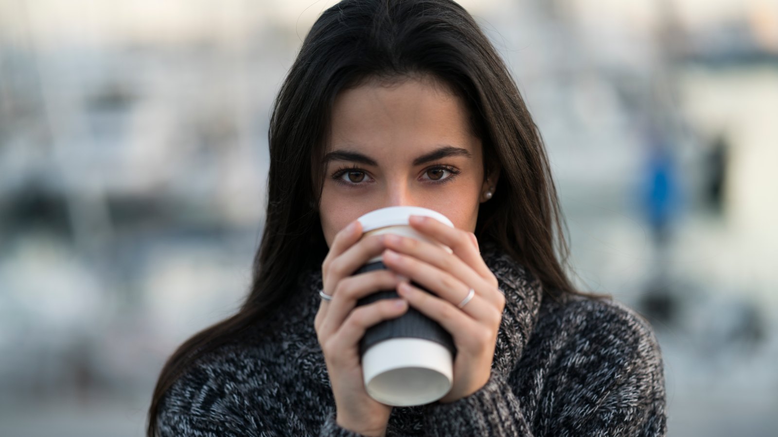woman drinking from coffee cup in sweater