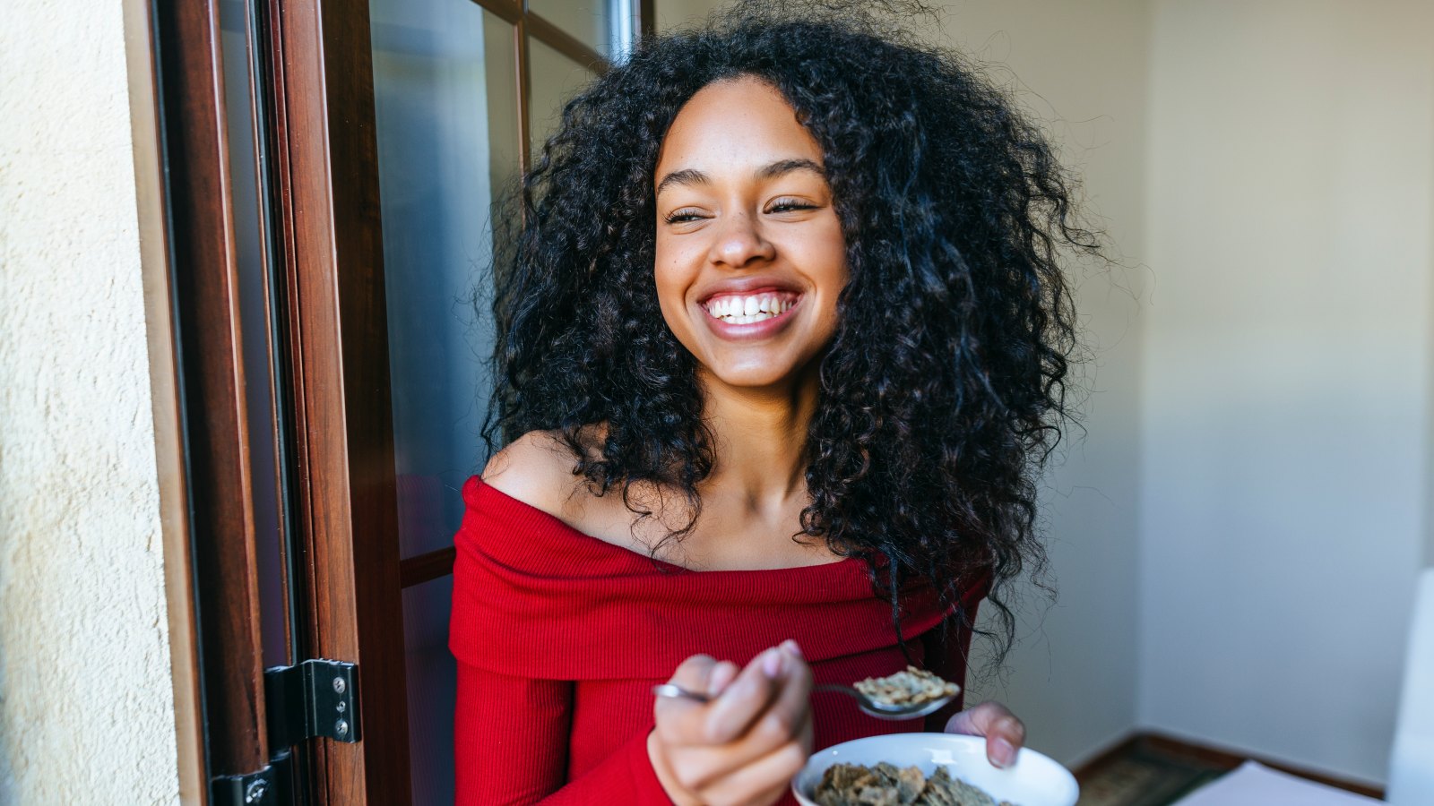 woman smiling and eating cereal