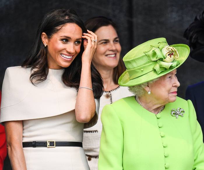 Queen Elizabeth II stands with Meghan, Duchess of Sussex accompanied by Samantha Cohen