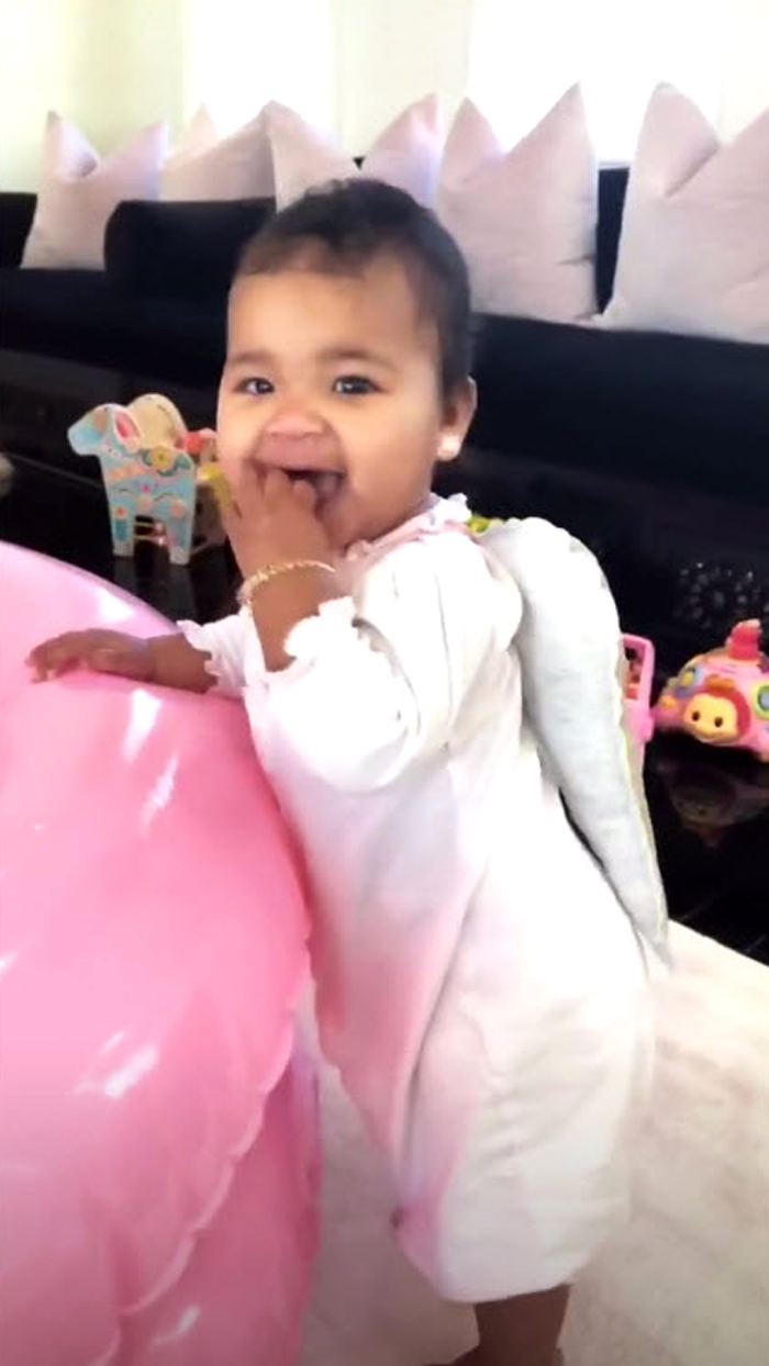 khloe kardashian shares videos of true wearing gold angel wings, playing with Christmas toys
