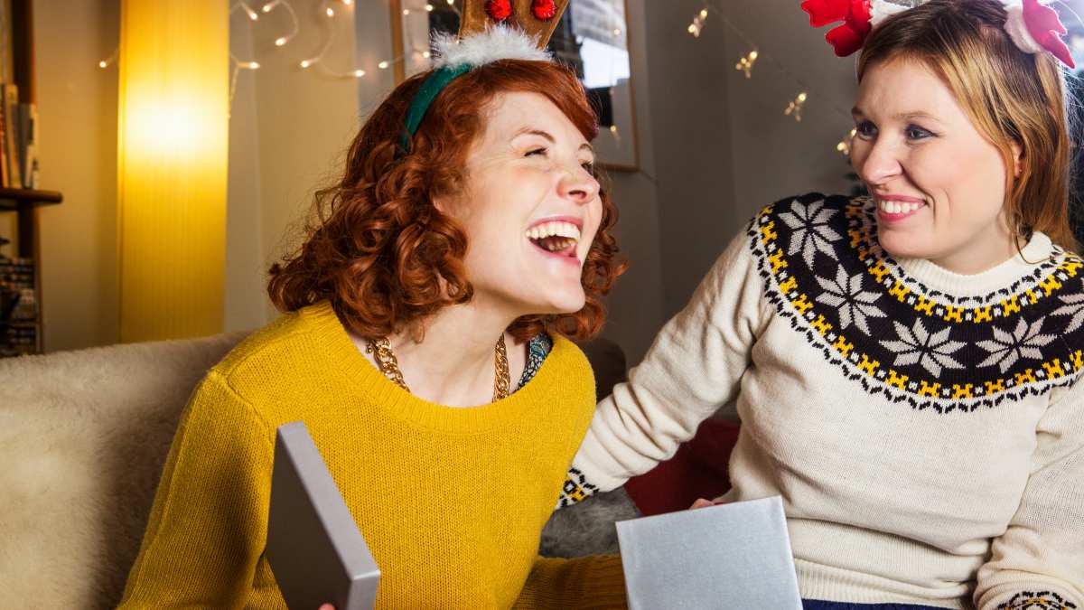 Woman is pleased when opening Christmas present.