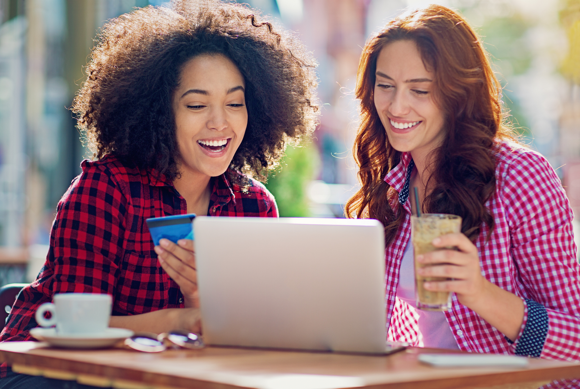 Girlfriends are shopping online in a cafe