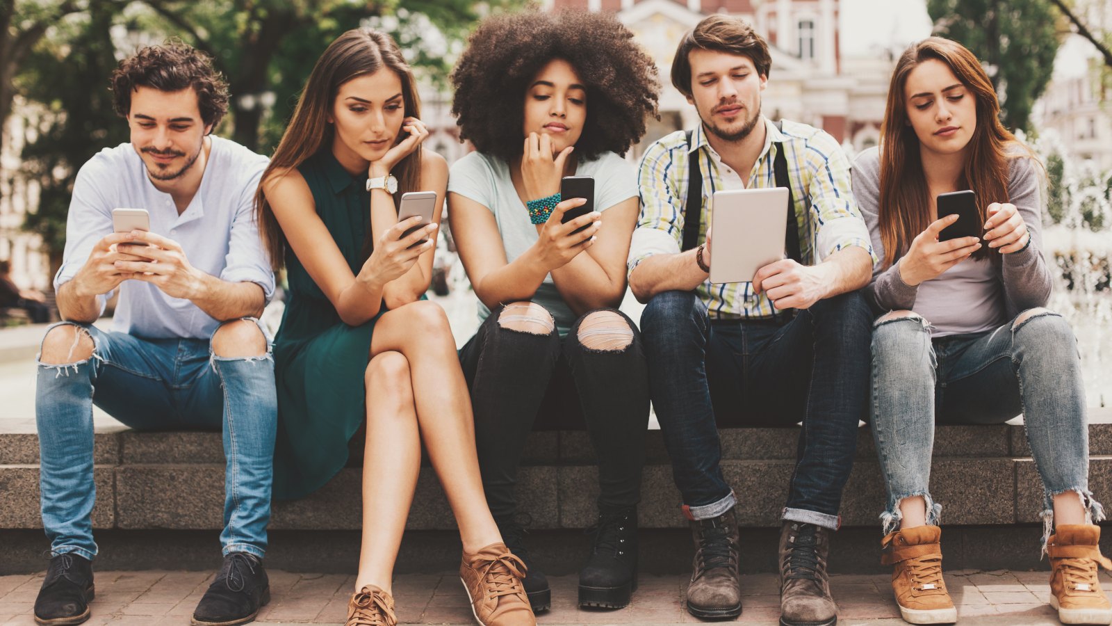 Group of mixed race people looking at mobile phones