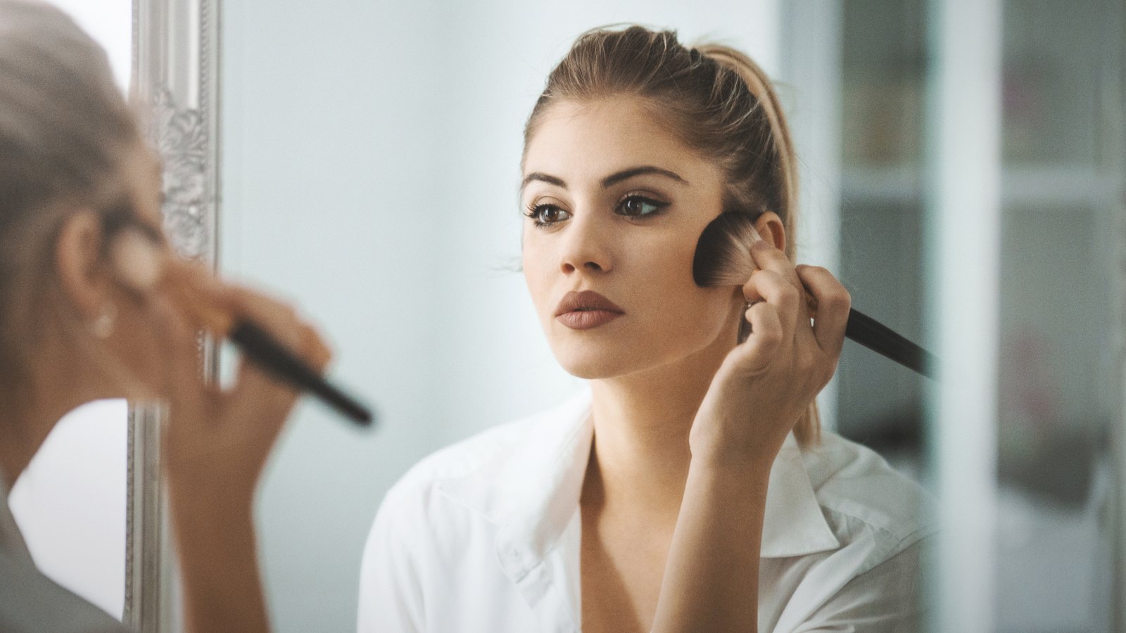 woman putting on makeup