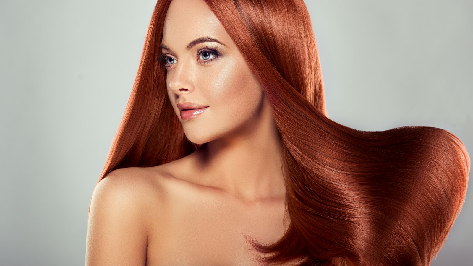 Young, brown haired woman with straight and voluminous hair. Beautiful model with long, dense straight hairstyle and vivid make-up. Perfect hair wave and sexy look.Incredibly dense, wavy,and shiny hair.