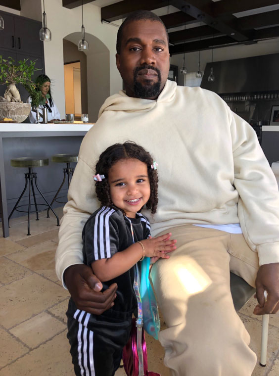 Kayne West Wearing a White Hoodie Holding Dream