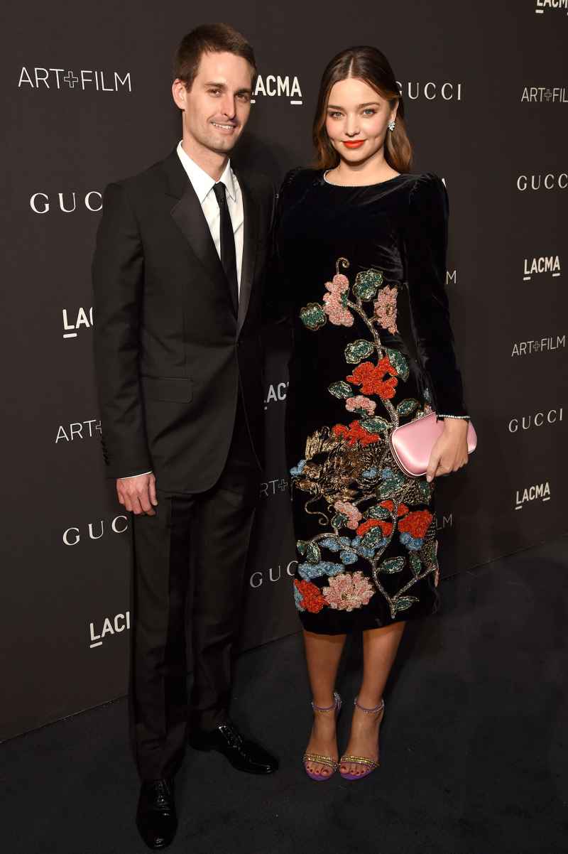 Evan Spiegel and Miranda Kerr Inside Pregnant Life Black Suit Black Dress WIth Flowers and Pink Hand Bag Purse