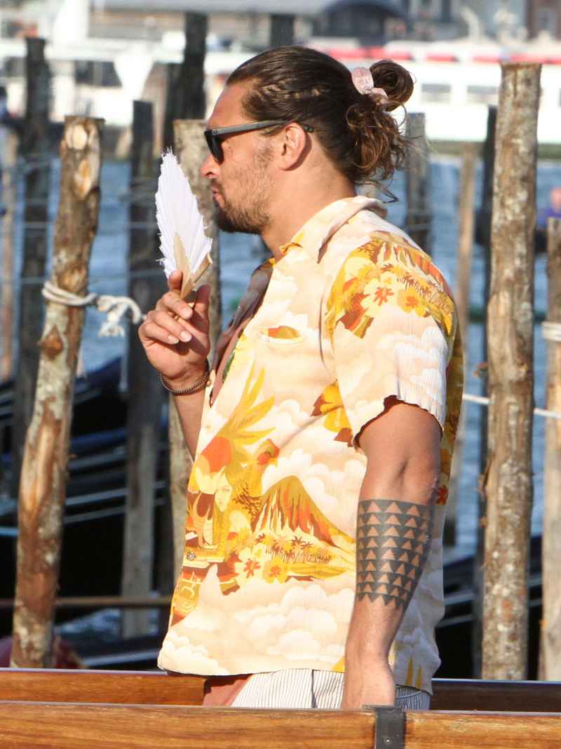 Jason Momoa In A Colorful Shirt Holding A Fan