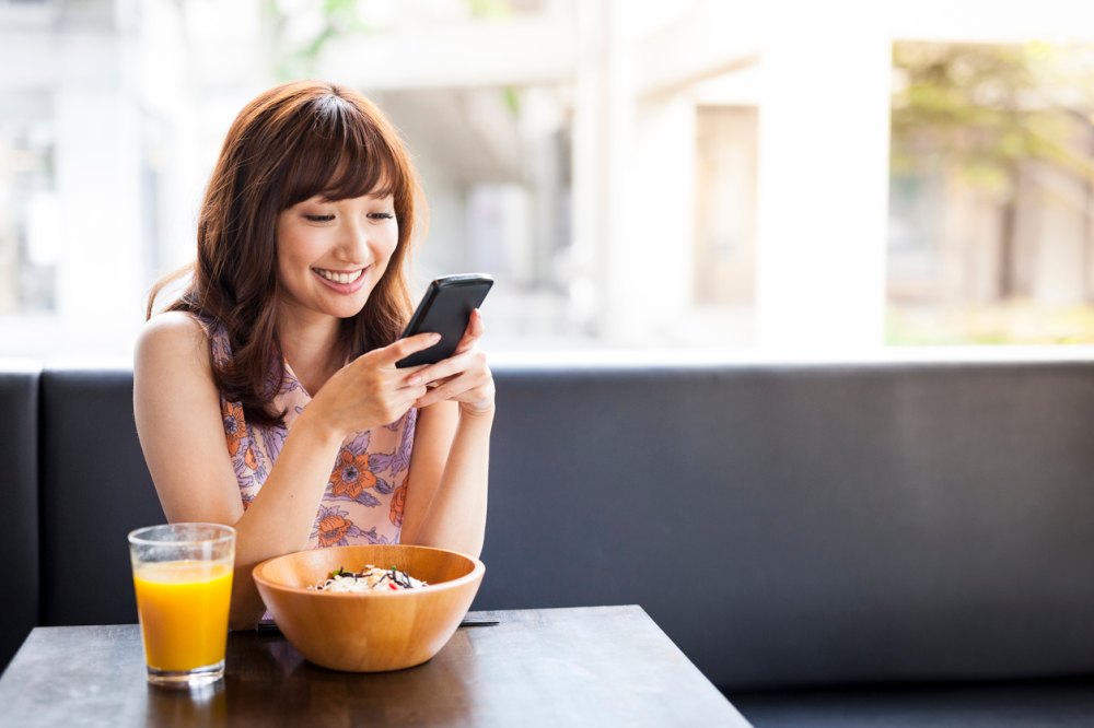 Content smiling girl looking at phone screen in her hands