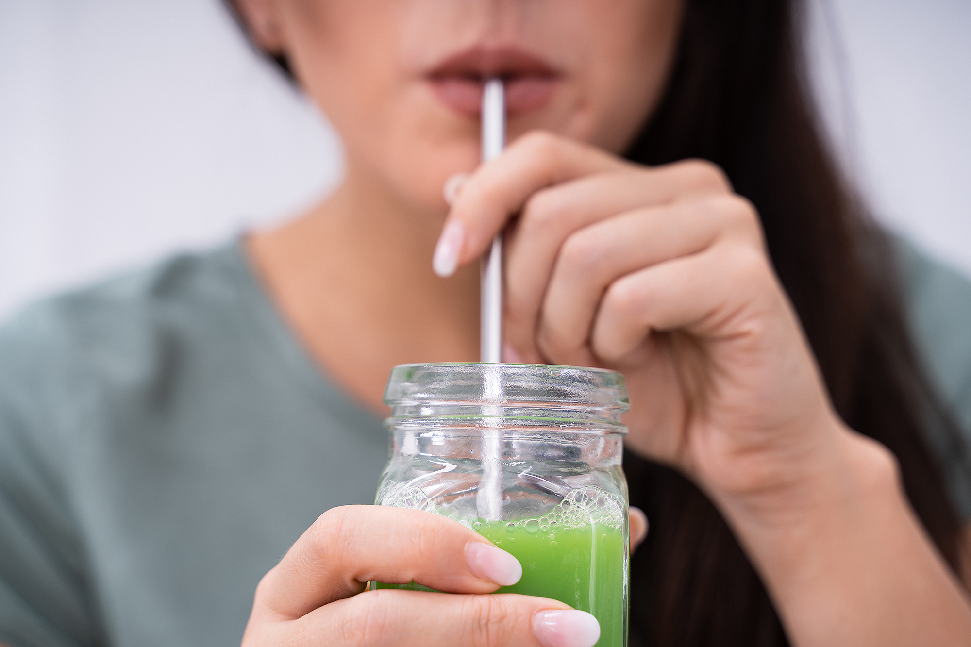 woman drinking green juice