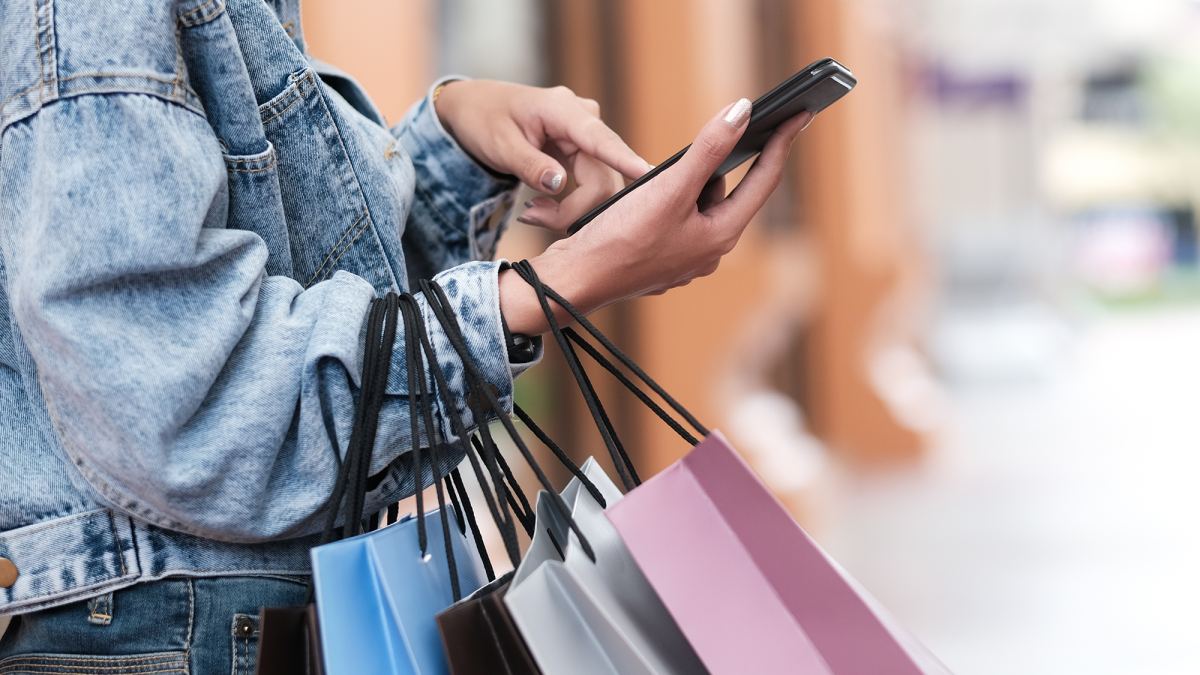 Closeup woman hand using mobile phone in shopping checking sales promotion.