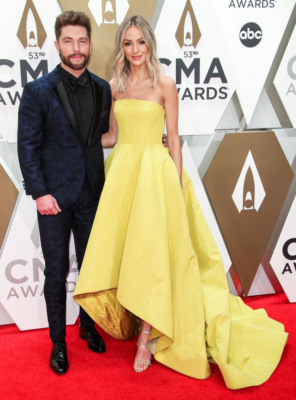 Chris Lane and Lauren Lane 2019 CMA Awards Arrival Red Carpet Yellow Dress