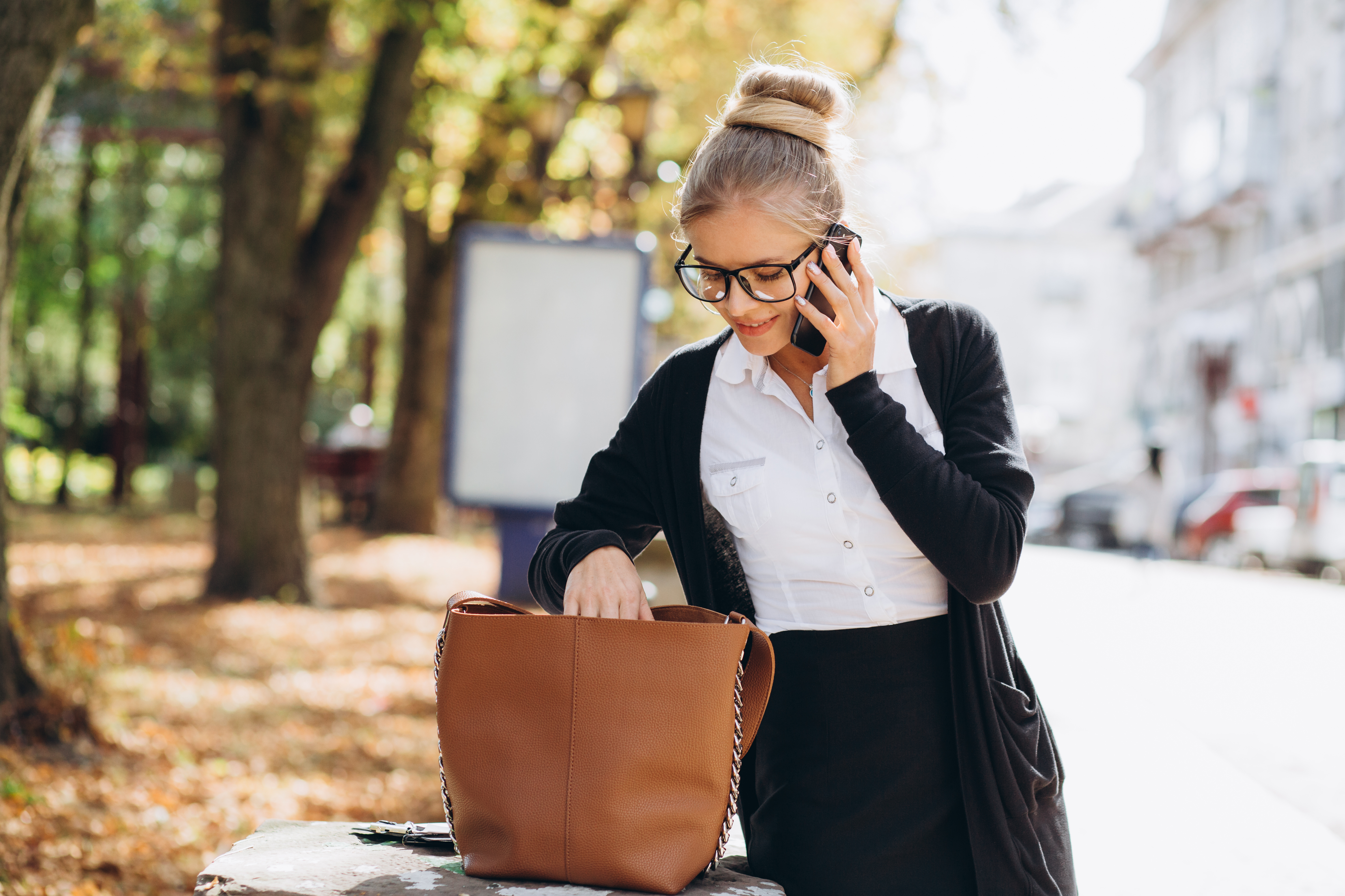 woman looking for something in handbag