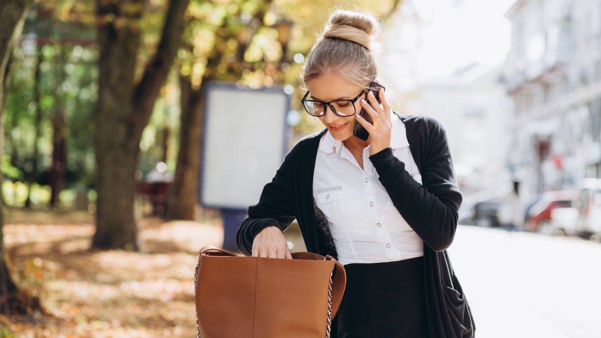 woman looking for something in handbag