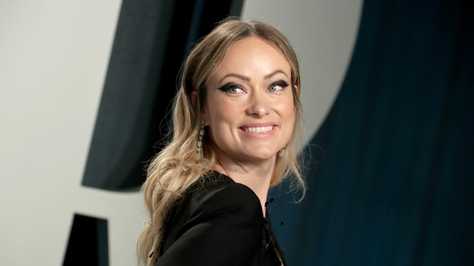 Olivia Wilde looks fabulous in a white tank top and teal-blue leggings as  she hits