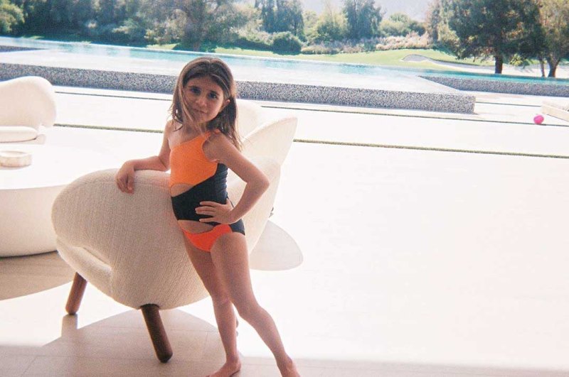 Penelope Disick in an orange and black one-piece bathing suit