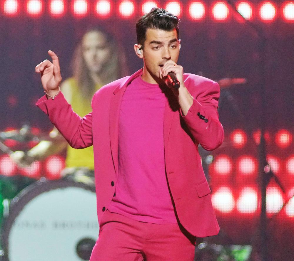 Joe Jonas of The Jonas Brothers performs in a pink suit during their Happiness Begins Tour Joe Jonas Pays Tribute to His Squad on National Dog Day
