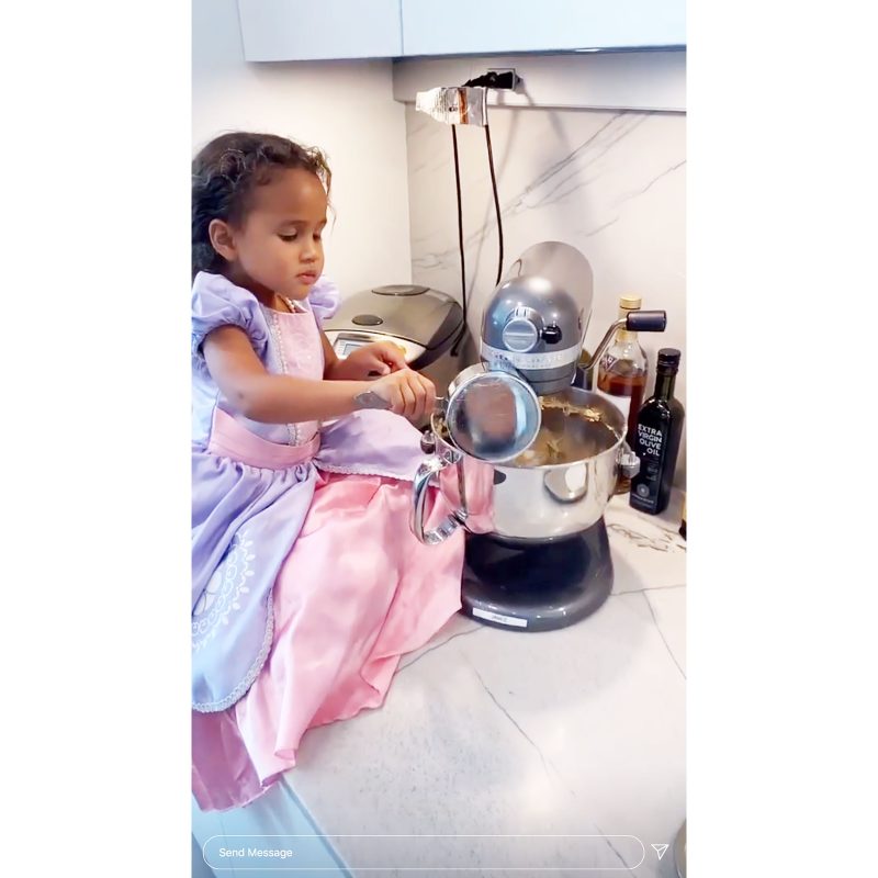 Chrissy Teigen Daughter Luna Uses mixer in a princess gown and a pearl necklace