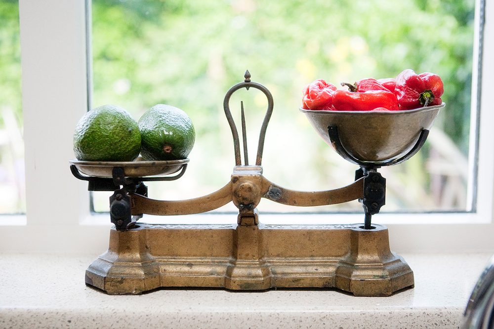 avacados and red peppers on an antique kitchen scales