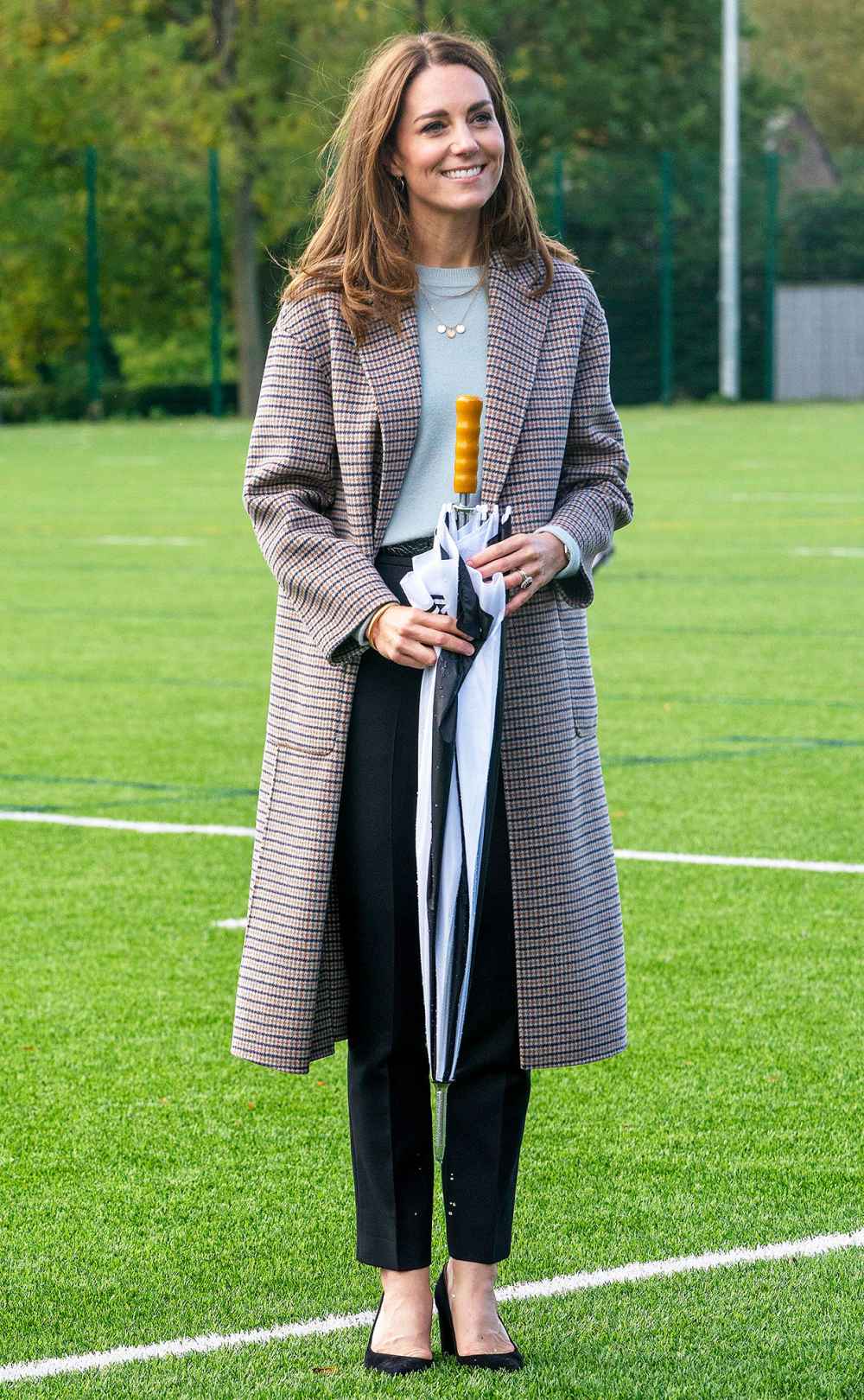 Duchess Kate Visiting The University Of Derbvy In A Plaid Coat And Carrying An Umbrella