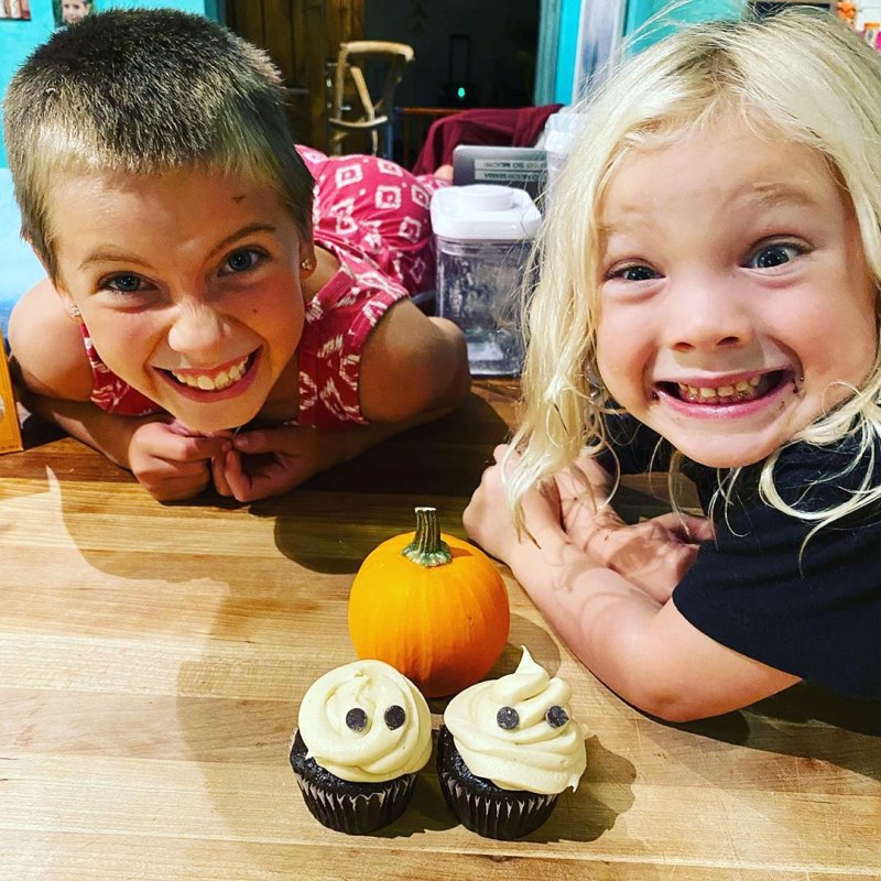 Willow and Jameson smiling beside a mini pumpkin and two ghost-themed cupcakes