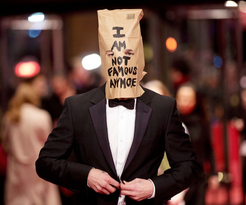 Shia LaBeouf poses for photographers, with a paper bag over his head that says I am not famous anymore Shia LaBeouf Ups and Downs Through the Years