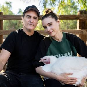 Joaquin Phoenix and Rooney Mara hold a chicken at California's Farm Sanctuary.