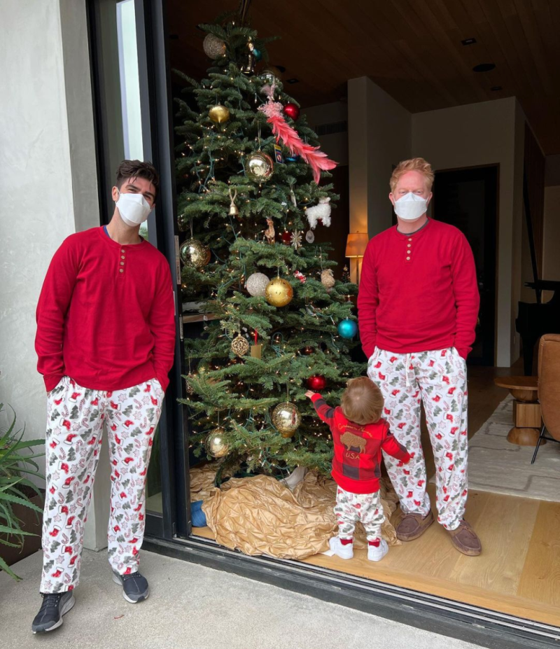 Jesse Tyler Ferguson and Justin Mikita pose with their son in Christmas pajamas.