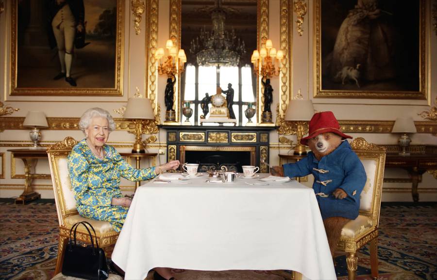 Queen Elizabeth II and Paddington Bear having cream tea at Buckingham Palace