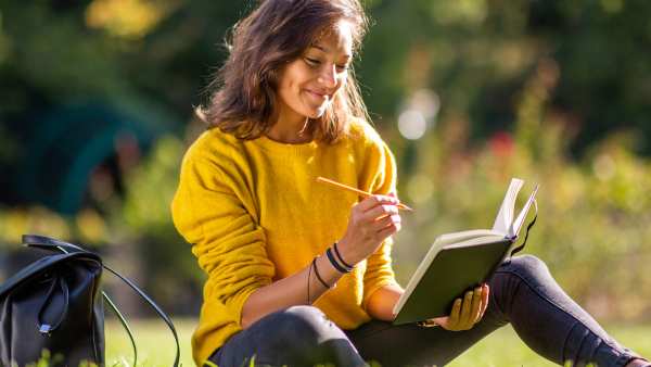 Woman-Journaling-In-The-Park-Stock-Photo